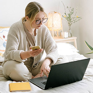 Woman with laptop on bed