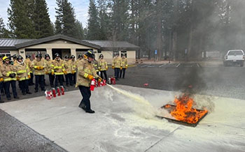 Fire students putting out small fire with fire extinguisher